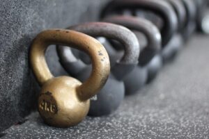 دمبل و کتل‌بل روی زمینِ باشگاه؛ نمادی از نظم و تمرینِ پیوسته
