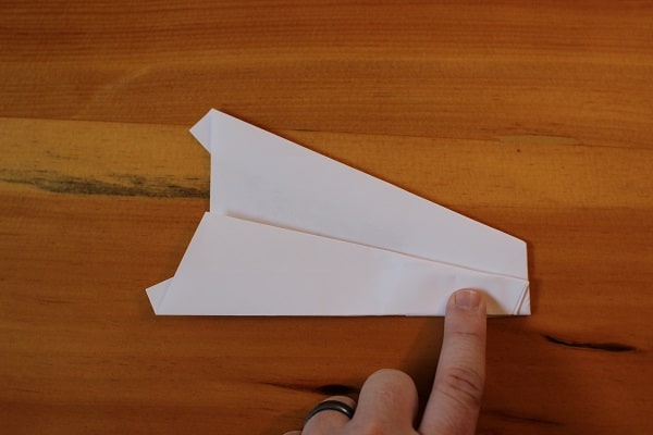 Fold wings down to meet bottom edge of plane.