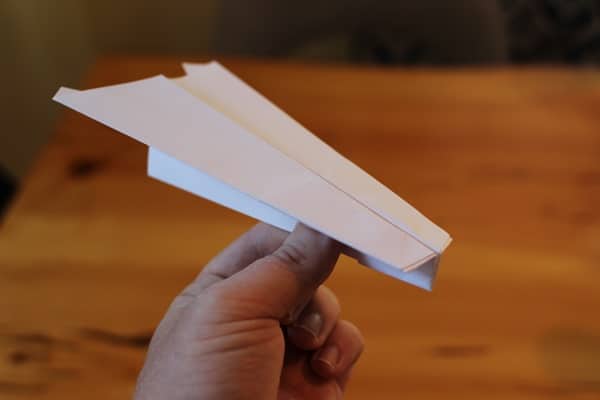 Man holding a paper airplane.